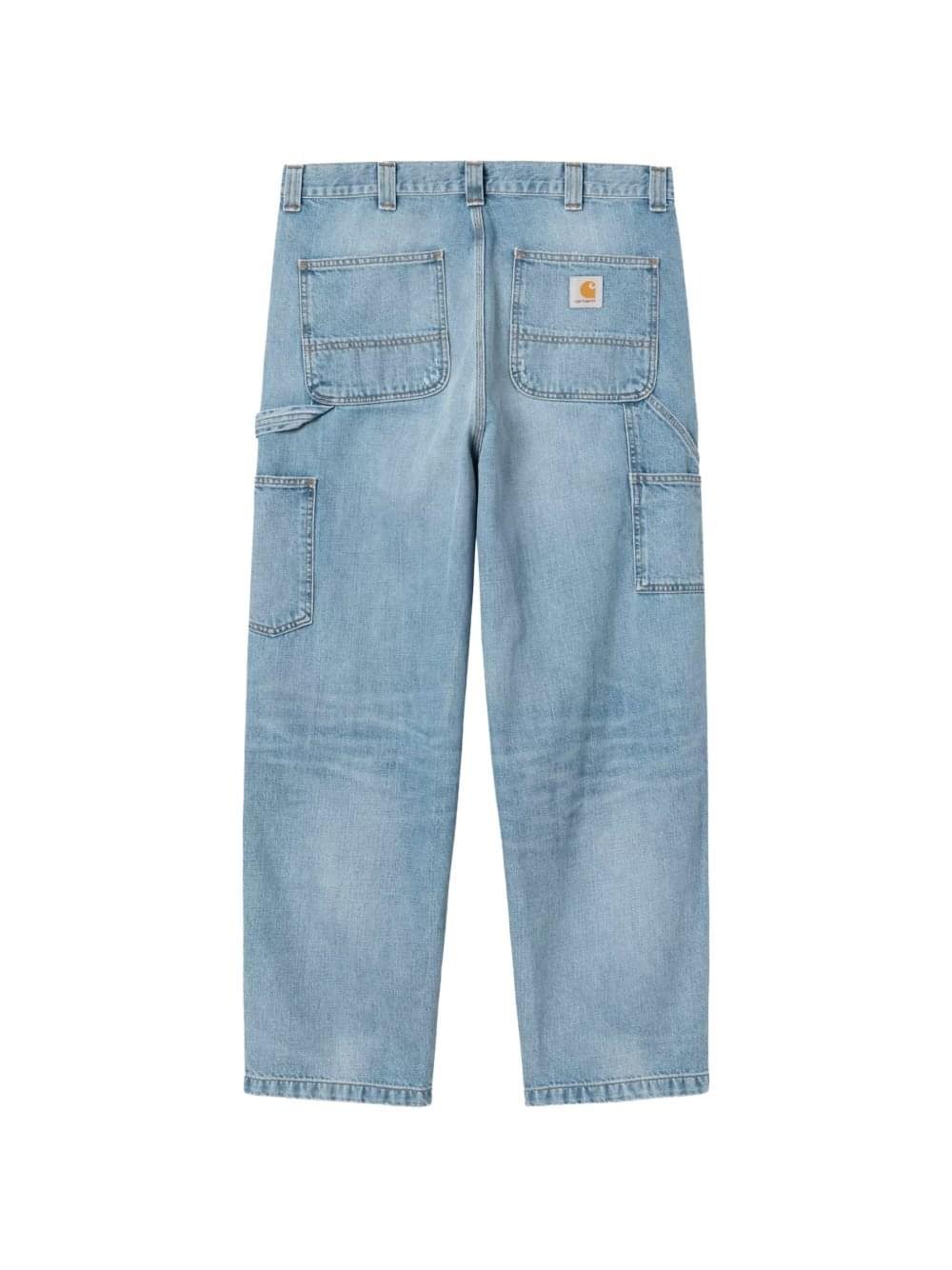 Carhartt Wip Main denim cotton jeans displayed on a hanger, showcasing classic fit and durable fabric with visible stitching details.