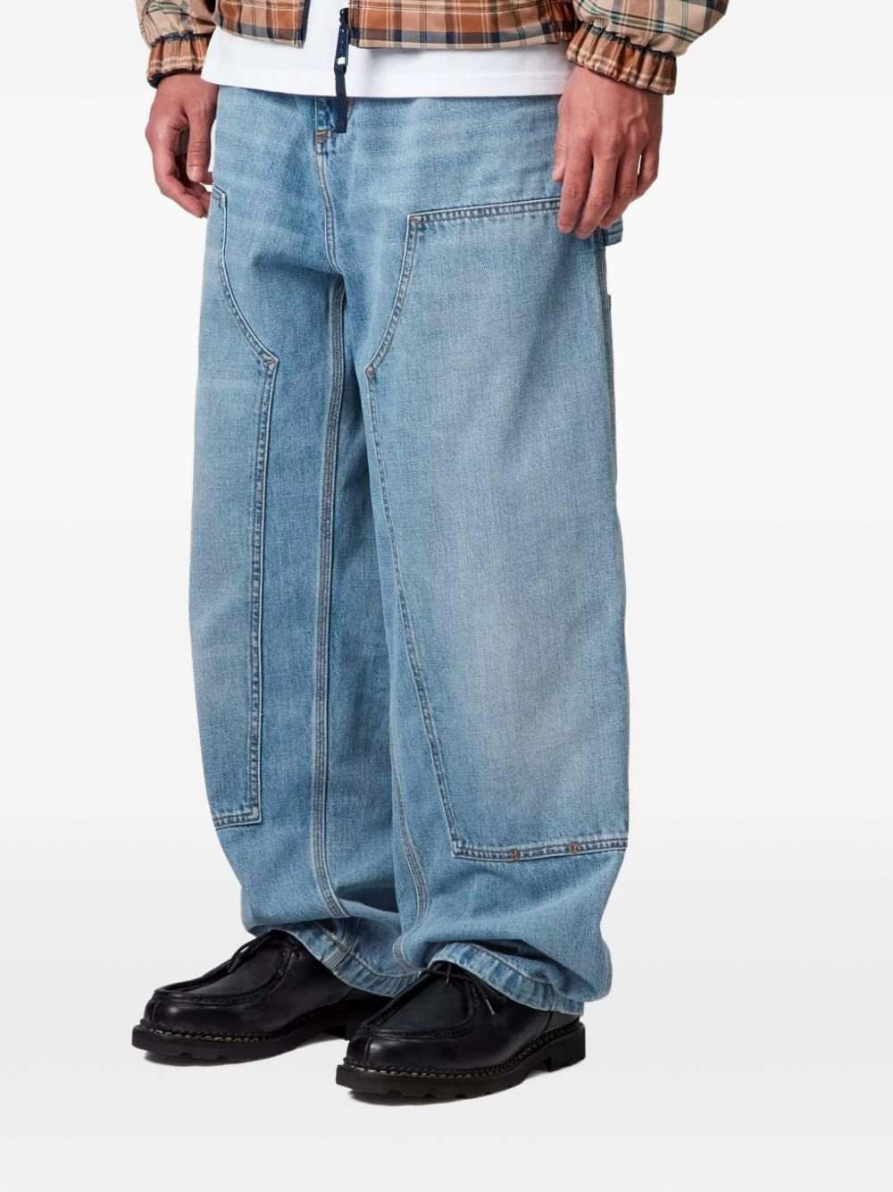 Carhartt Wip Main denim cotton jeans with classic five-pocket design and straight-leg fit, shown hanging on a rack.