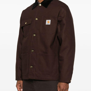 Carhartt Wip Main jacket in dark color with front pockets, casual style, made of durable fabric, displayed on a hanger.