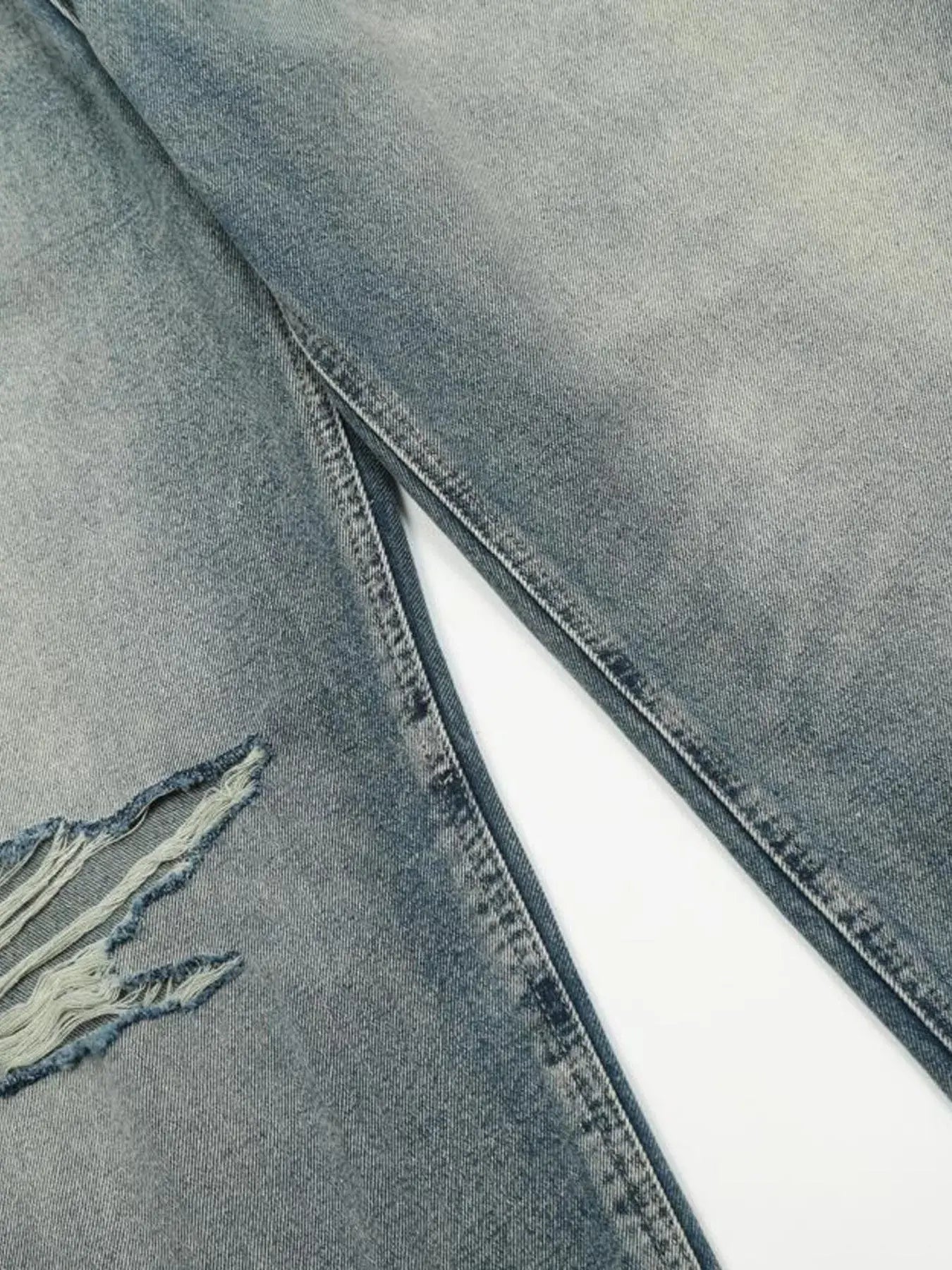 Washed blue distressed vintage jeans by Luxenk© featuring a relaxed fit and faded details, styled with casual wear.