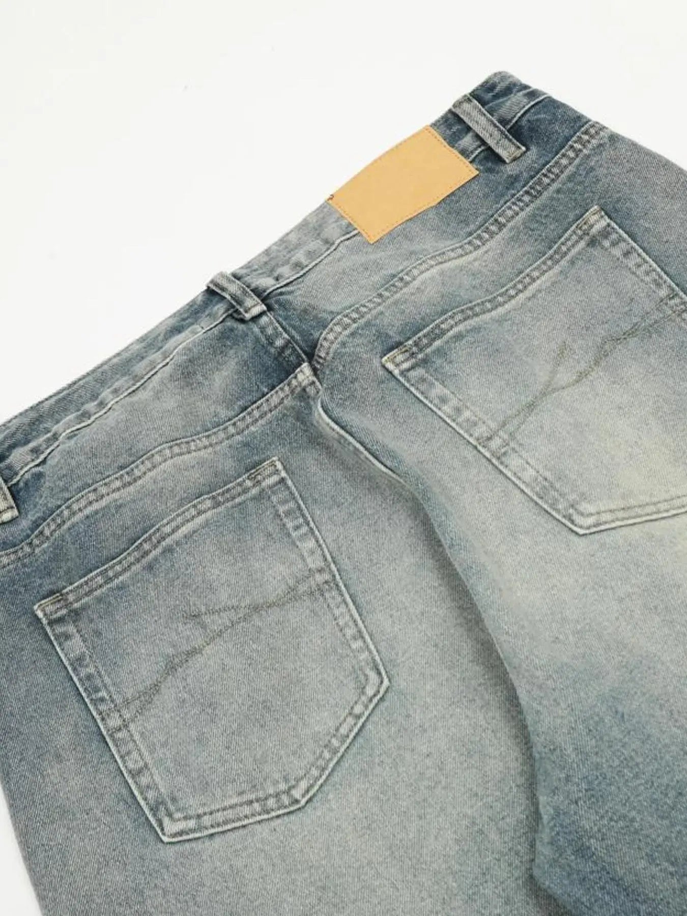 Washed blue distressed vintage LUXENK© jeans with frayed hems and fading, casual fit, shown on a model for trendy everyday wear.