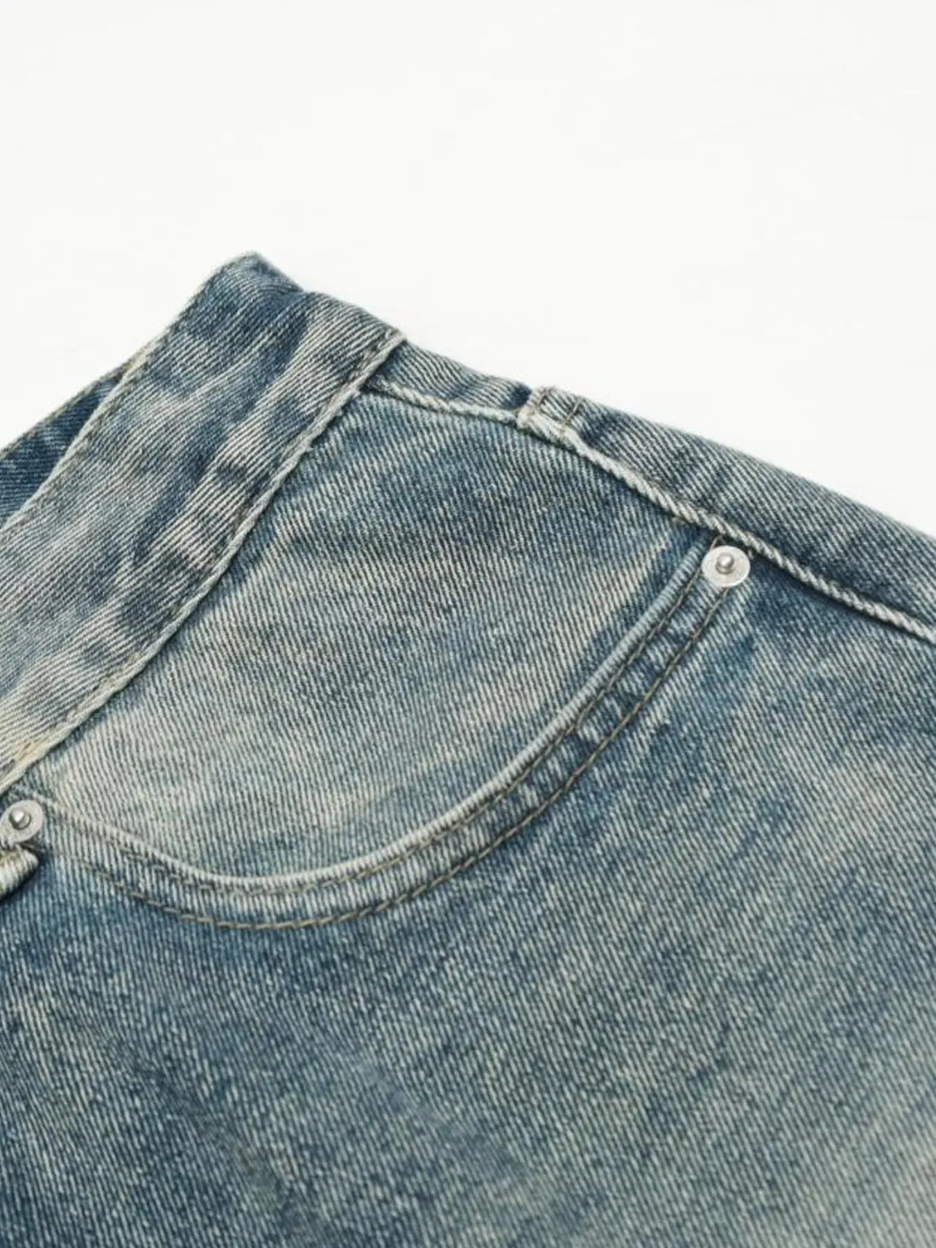 Washed blue distressed vintage jeans by Luxenk© featuring a relaxed fit and faded denim, displayed on a white background.