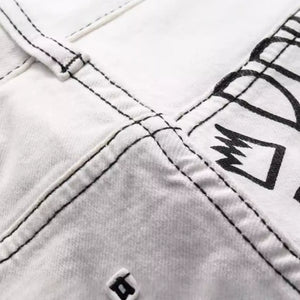 White Luxenk© "Graffiti Slim" jeans by Trendsi, showcasing a slim fit design with detailed graffiti-inspired stitching.
